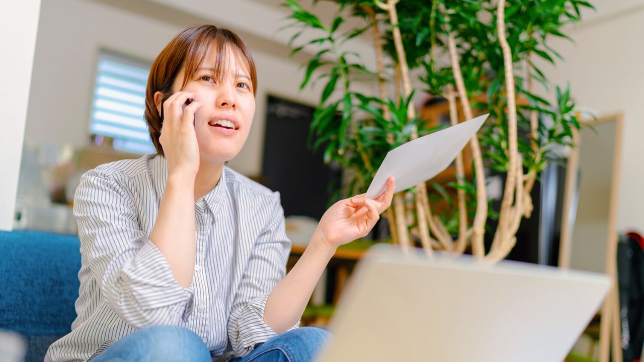 Woman on the phone holding a paper
