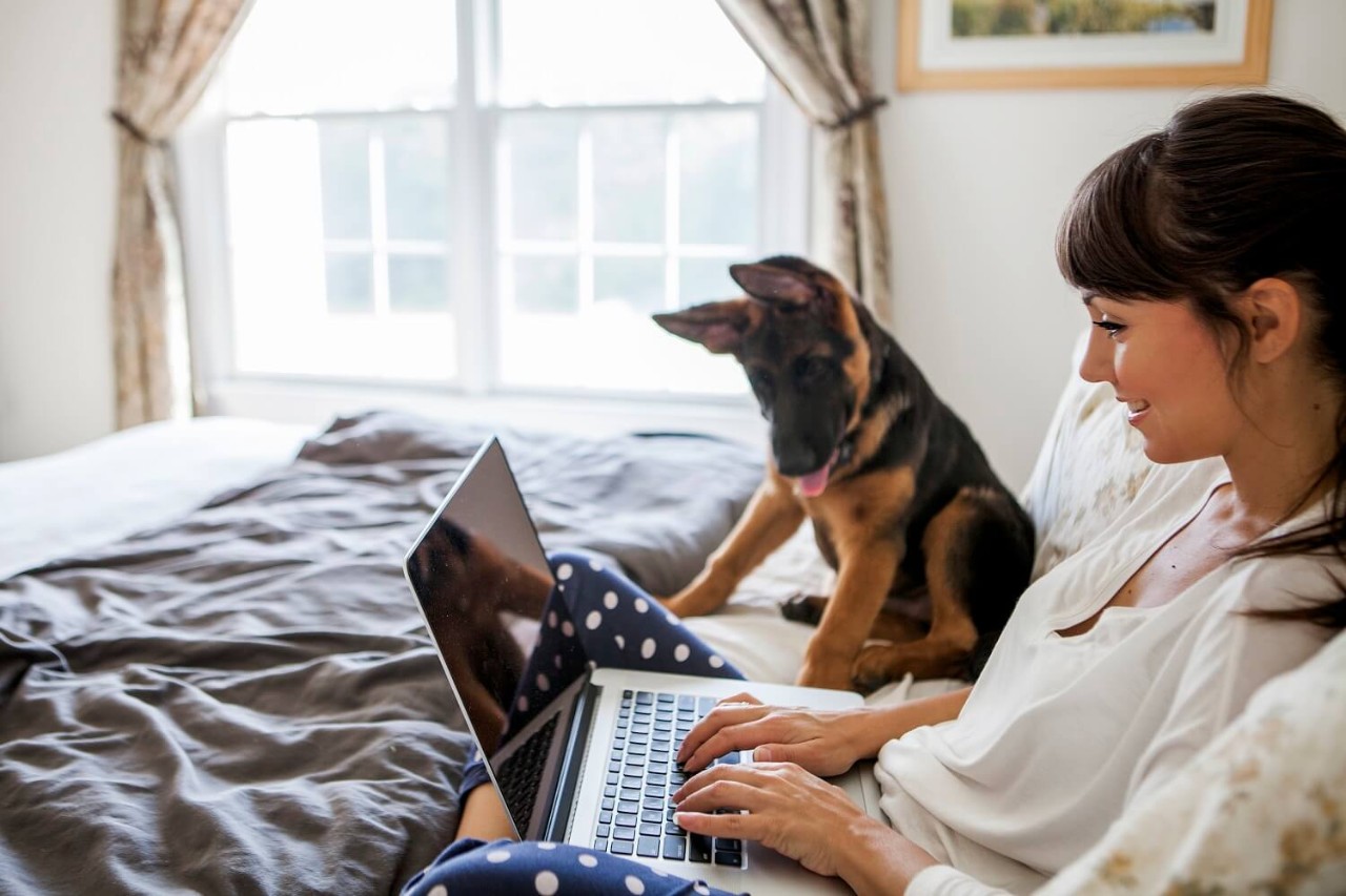 woman with her dog on a bed